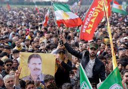 　トルコのクルド労働者党（ＰＫＫ）の指導者オジャラン受刑者が描かれた旗を持つ人＝３月２３日、イスタンブール（ロイター＝共同）