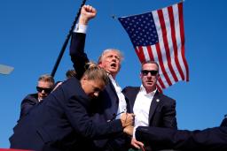 　昨年７月、選挙集会で銃撃を受け、大統領警護隊に囲まれながら拳を上げるトランプ氏＝米ペンシルベニア州バトラー（ＡＰ＝共同）