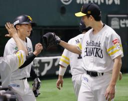 　６回、佐藤直の適時打で生還し、大関（右）とタッチを交わすソフトバンク・野村＝みずほペイペイドーム
