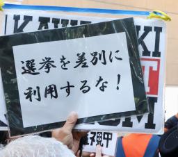 　参院選候補者の街頭演説に対し、抗議のメッセージを掲げる人＝１２日、川崎市