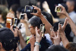 　参院選の候補者らの街頭演説をスマートフォンで撮影する人たち＝１９日、札幌市