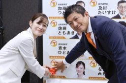 　東京選挙区で当選を決めたさや氏（左）と花を付ける参政党の神谷代表＝２０日午後９時１１分、東京都新宿区