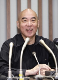 　インターネット番組の中継が始まり、笑顔を見せる日本保守党の百田代表＝２０日午後８時、東京都中央区