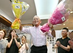 　兵庫選挙区で当選を決め、花束を手に笑顔の泉房穂氏＝２０日夜、神戸市中央区