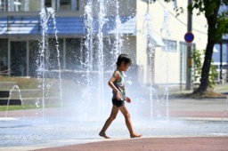 　気温が上昇した北海道帯広市。人影まばらな公園の噴水で遊ぶ子ども＝２４日午後１時２１分
