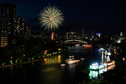 　奉納花火が夜空を彩り、大川を船が行き交う天神祭の「船渡御」＝２５日夜、大阪市