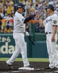 　１回、先制打を放ちコーチ（右）とタッチを交わす阪神・大山＝甲子園