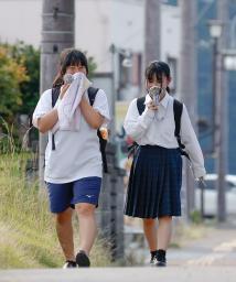 　小型扇風機を手に兵庫県丹波市柏原町地区を歩く人たち。国内最高気温を更新した＝３０日午後