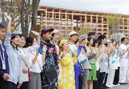 　４月、大阪・関西万博が開幕し来場者を迎えるスタッフら＝大阪市此花区の夢洲