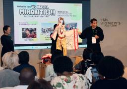 　徳島の人形芝居「阿波木偶箱まわし」の歴史を説明する保存会顧問の辻本一英さん（奥右）＝１日午後、大阪市此花区の夢洲