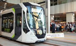 　広島電鉄の新線「駅前大橋線」が開業し、広島駅電停を出発する一番電車＝３日早朝、広島市南区