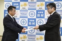 　資源エネルギー庁幹部から北海道電力泊原発３号機の再稼働に関する文書を受け取る北海道泊村の高橋鉄徳村長（左）＝４日午前、泊村役場