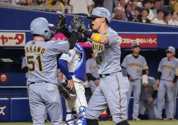 　８回、３ランを放ち中野（左）とタッチを交わす阪神・佐藤輝＝バンテリンドーム