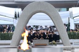 　米軍の原爆投下から８０年の「原爆の日」となり、慰霊碑に手を合わせる人たち＝６日午前５時３６分、広島市中区の平和記念公園