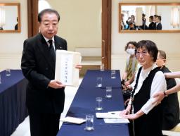　被爆体験者の岩永千代子さん（右）から石破首相宛ての要望書を預かった立憲民主党の野田代表＝９日午前、長崎市