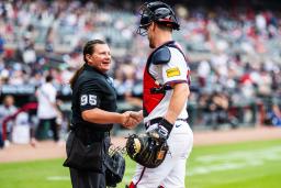 　米大リーグの公式戦で捕手と握手するパウォルさん＝１０日、アトランタ（ゲッティ＝共同）