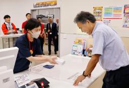 　新庁舎で開局した穴水郵便局を訪れた利用客（右）＝１２日午前、石川県穴水町