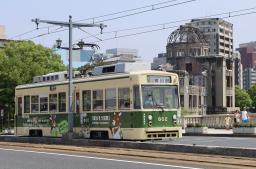 　原爆ドーム（右奥）の近くを走る広島電鉄の路面電車＝１３日午後、広島市中区