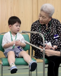 　全国戦没者追悼式を前に取材に応じる最年少参列者の片山純矢ちゃん。右は曽祖母の伊藤早苗さん＝１５日午前１０時２１分、東京・日本武道館