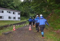 　１５日午前、閉鎖された羅臼岳の登山口から入山する捜索隊＝北海道斜里町