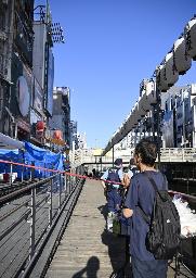 　消防隊員２人が犠牲になった大阪・道頓堀のビル火災現場で手を合わせる男性＝１９日午後