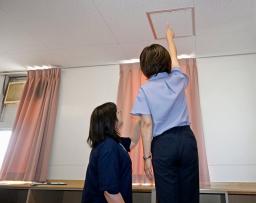 　栃木県内の県立高校で女子更衣室の点検口を確認する教職員＝２０日午前