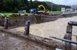 　秋田県仙北市で大雨のため壊れた桧木内川に架かる橋（手前）と崩れた道路（奥）＝２０日午後３時２５分