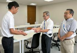 　福井県美浜町役場で、町職員（左）に要望書を提出する原告団長の中島孝さん＝２１日午前