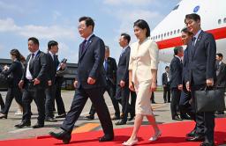 　羽田空港に到着した韓国の李在明大統領（中央左）と妻の金恵景氏＝２３日午前