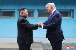 　板門店で対面し、握手する北朝鮮の金正恩朝鮮労働党委員長（左）とトランプ米大統領＝２０１９年６月３０日（朝鮮中央通信＝共同）