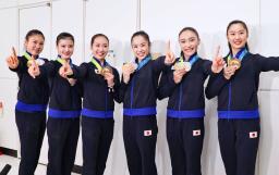 　帰国した成田空港でポーズをとる新体操の世界選手権で団体総合初の金メダルを獲得した鈴木歩佳（中央右）ら日本代表＝２６日