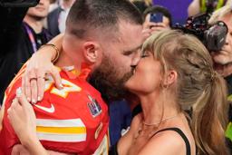 　昨年２月、スーパーボウルの試合を終えたチーフスのトラビス・ケルシー選手（左）とキスするテイラー・スウィフトさん＝米ラスベガス（ＡＰ＝共同）