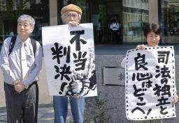 　九州電力川内原発１、２号機を巡る訴訟の控訴審判決で、請求を退けられ「不当判決」などと書かれた紙を掲げる原告団のメンバーら＝２７日午後、福岡高裁前