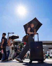 　名古屋市で日傘を差して歩く人たち。最高気温４０度を観測した＝３１日午後
