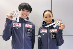 　ジュニアＧＰシリーズ第２戦トルコ大会で獲得したメダルを掲げる女子優勝の岡万佑子（右）と男子２位の高橋星名＝１日、成田空港