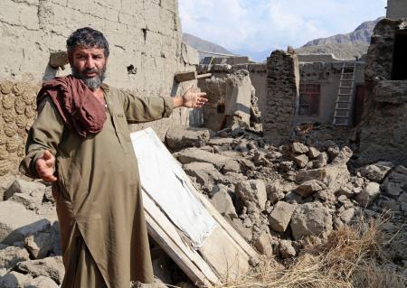 　アフガニスタン東部の地震で家屋が倒壊し、娘が下敷きになった現場を説明するリヤカット・アリさん＝５日、クナール州ヌールガル（共同）
