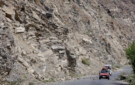 　アフガニスタン東部クナール州ヌールガルで、落石を避けて通る車＝５日（共同）