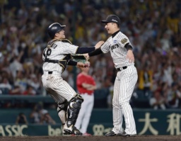 　リーグ優勝を決め、抱き合う阪神の岩崎（右）と坂本のバッテリー＝甲子園