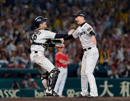 　リーグ優勝を決め、抱き合う阪神の岩崎（右）と坂本のバッテリー＝甲子園
