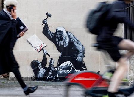 　デモ参加者に小づちを振り上げる裁判官を描いたとみられるバンクシーの新作＝ロンドン、撮影日不明（Ｂａｎｋｓｙ／ＰＡ通信＝共同）