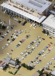 　鬼怒川の堤防決壊により浸水した茨城県常総市役所庁舎。災害派遣の自衛隊車両なども水に漬かった＝２０１５年９月