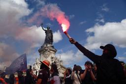 　発煙筒を掲げるフランス反政府デモの参加者＝１０日、パリ（ロイター＝共同）