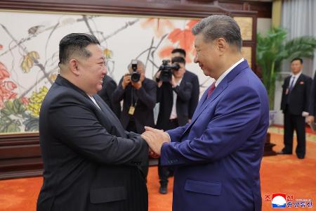 　握手する中国の習近平国家主席（右）と北朝鮮の金正恩朝鮮労働党総書記＝４日、北京（朝鮮中央通信＝共同）