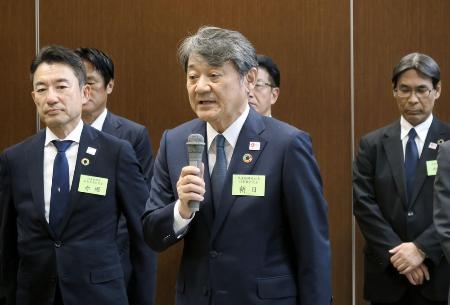 　記者団の取材に応じ、内部資料持ち出し問題について陳謝する日本生命保険の朝日智司社長（中央）＝７月、東京都千代田区