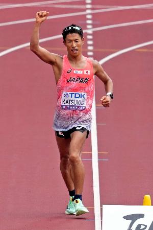 　陸上の第２０回世界選手権東京大会の男子３５キロ競歩で、ガッツポーズしながらゴールに向かう勝木隼人。銅メダルを獲得した＝１３日、東京・国立競技場