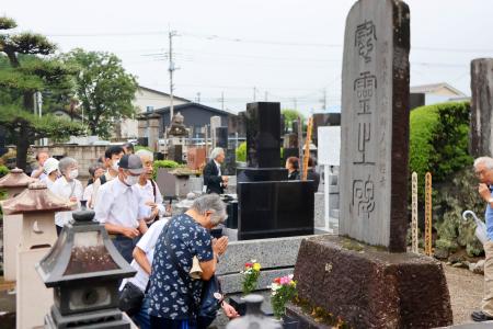 　藤岡事件の慰霊祭で、慰霊碑に手を合わせる参列者＝１３日午後、群馬県藤岡市