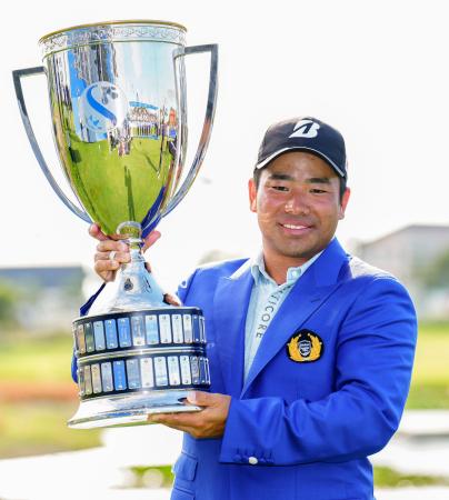 　通算１８アンダーで優勝し、トロフィーを手に笑顔の比嘉一貴＝ジャック・ニクラウスＧＣ（共同）