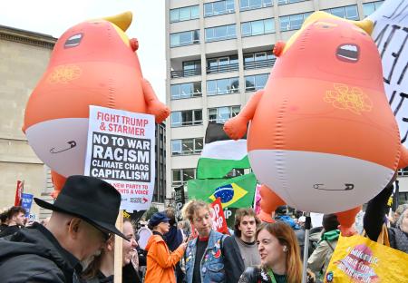 　トランプ米大統領を赤ちゃんに見立てた風船と、抗議デモに参加する人々＝１７日、ロンドン（共同）