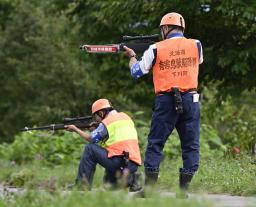 　研修会で、町から緊急銃猟の委託を受け証票となる腕章を着けて発砲までの工程を確認するハンター＝８月、北海道下川町
