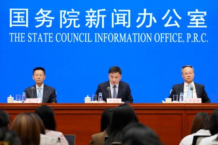 　記者会見する中国人民銀行の潘功勝総裁（中央）ら＝２２日、北京（共同）